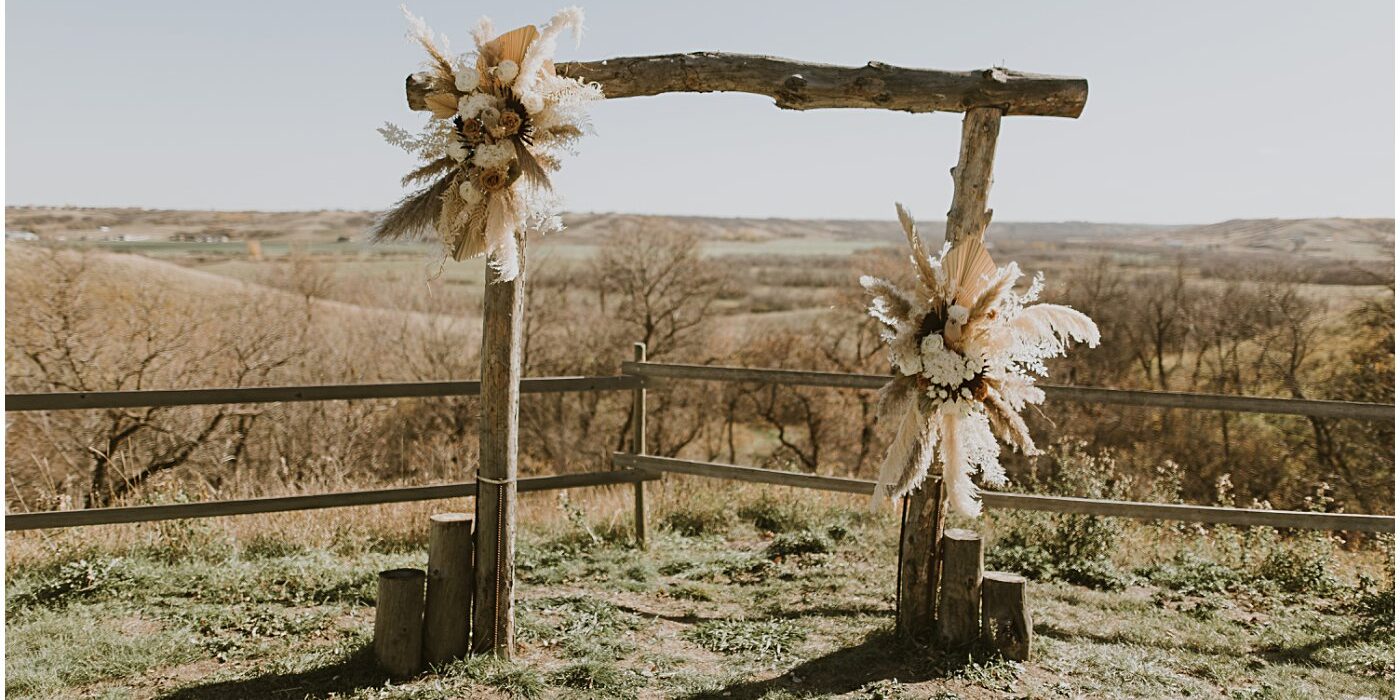 wedding ceremony arch overlooking the fall valley with neutral wedding florals