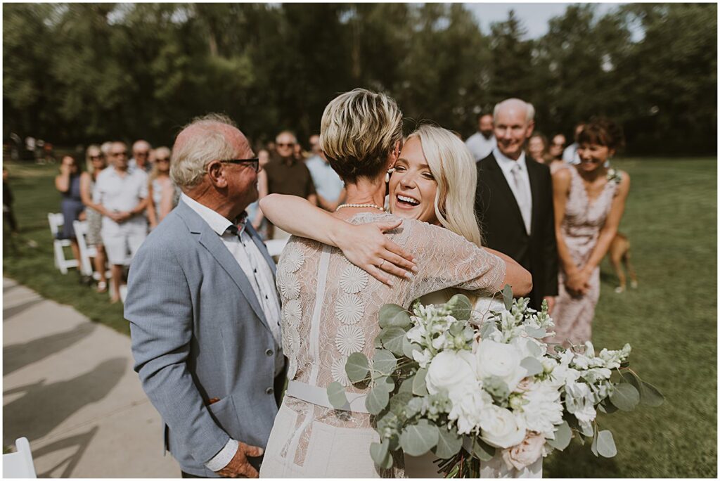 bride hugging parents at wedding ceremony