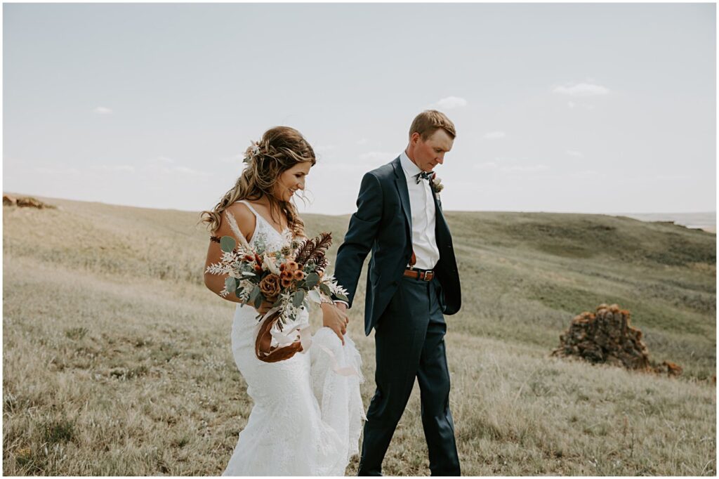 wedding couple walking holding wedding florals